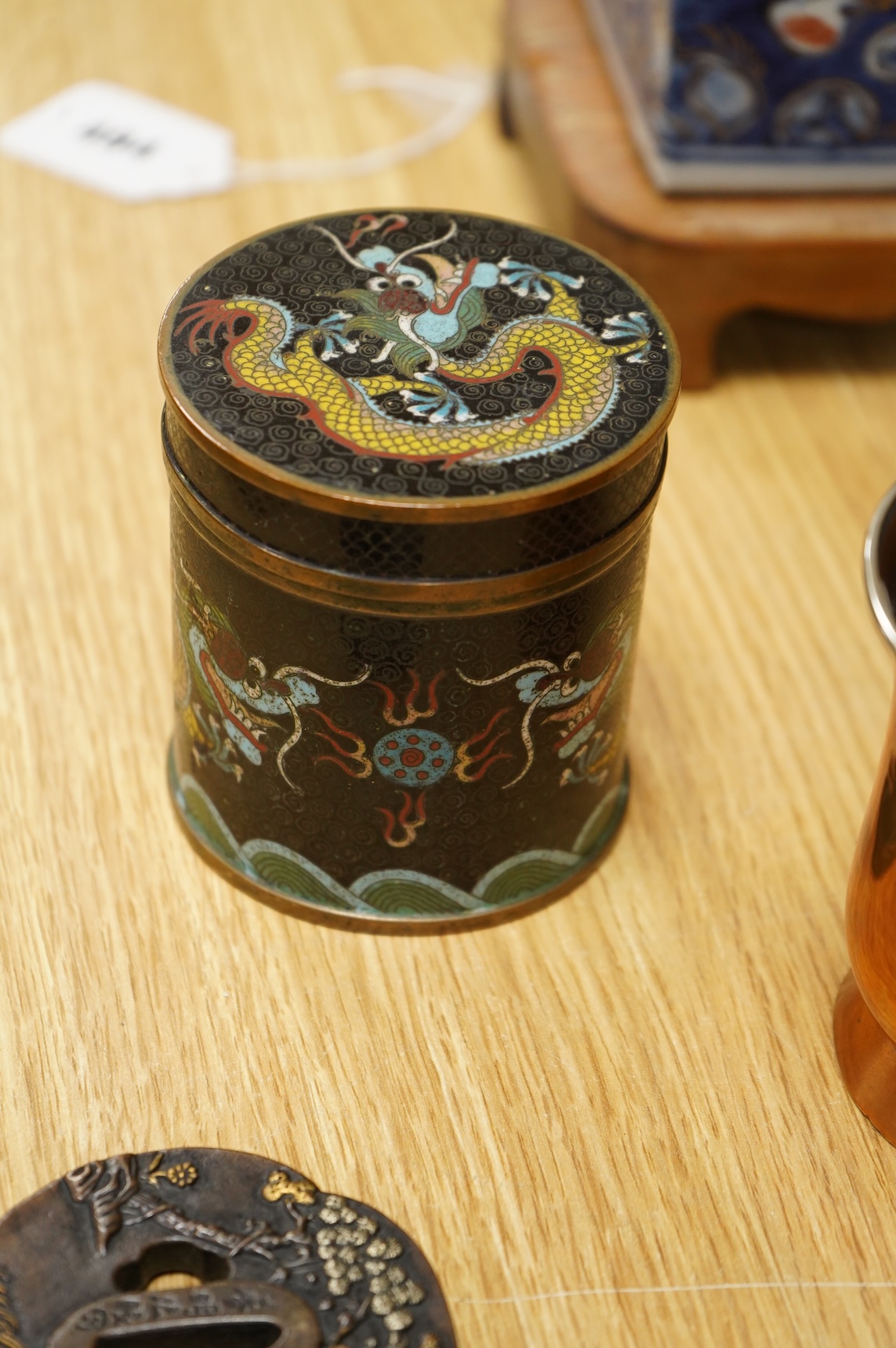 A Chinese cloisonné enamel ‘dragon’ jar and cover, a Chinese miniature four-fold table screen, two metalware tankards and a reproduction Japanese tsuba, cloisonne jar 9cm